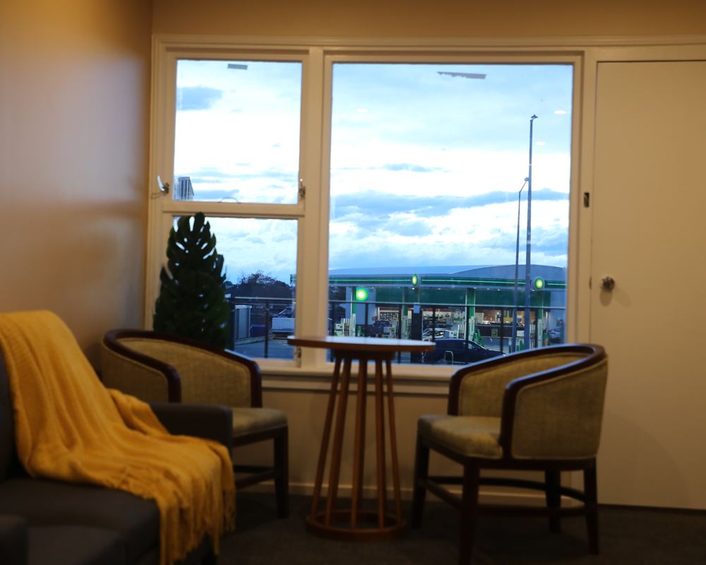 Suite lounge with armchairs by a large window at dusk